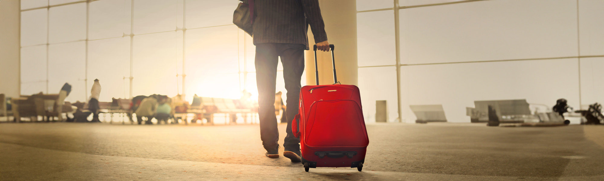 business walking through airport with luggage image