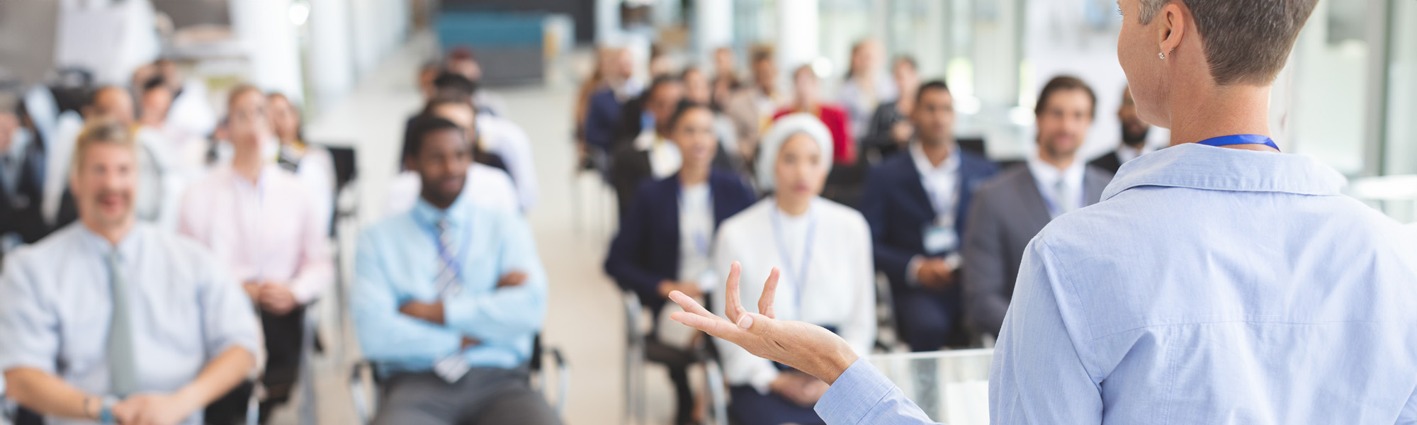 female speaker speaks in a business seminar image