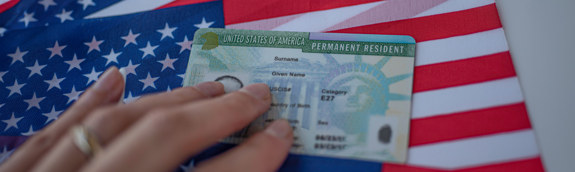 person holding green card on american flag image