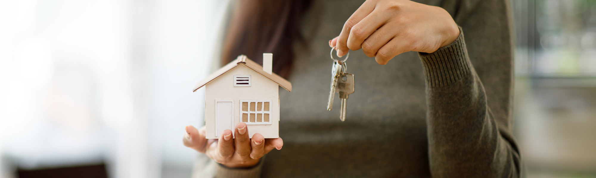 woman holding model house and keys image
