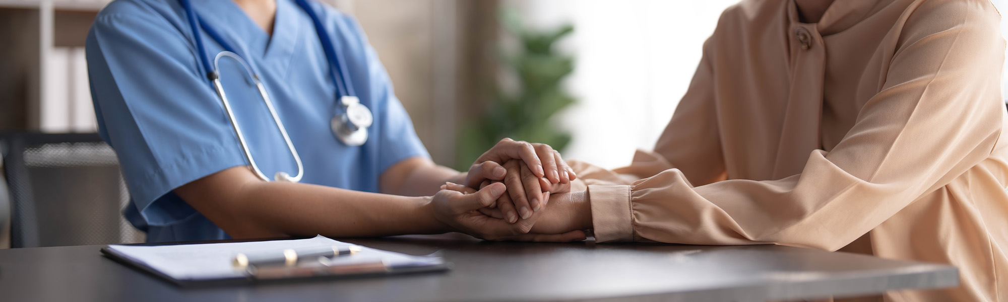 happy patient is holding caregiver for a hand while spending time together. elderly woman in nursing home and nurse image