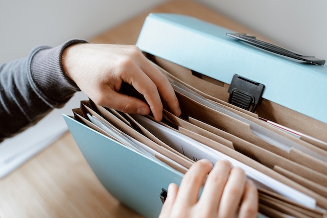 person sorting through file folder