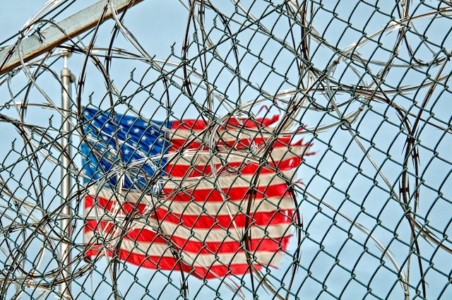 American Flag behind barbed wire fence