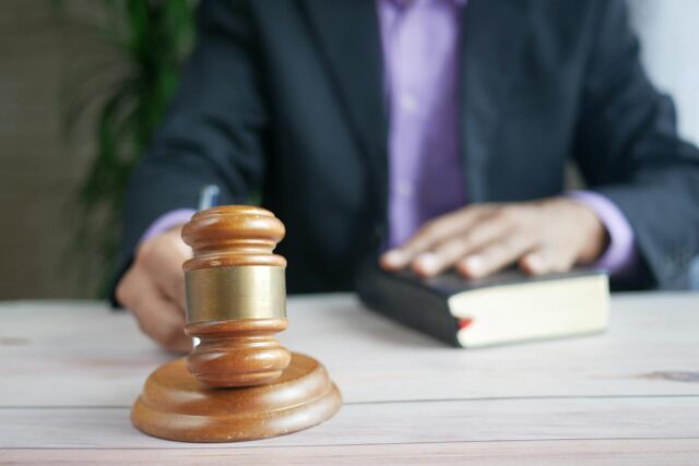 person in suit hitting gavel